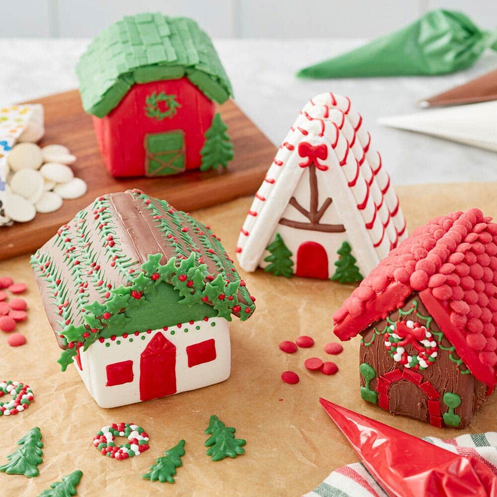 Mini village gingerbread houses decorated with red, green, white and light cocoa melted candy