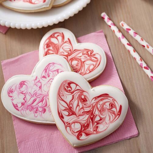 Heart-shaped cookies with marbleized royal icing in white, red, and pink