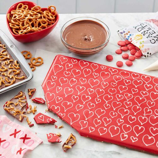 Sweet and salty red candy bark with white hearts, chocolate, and pretzels