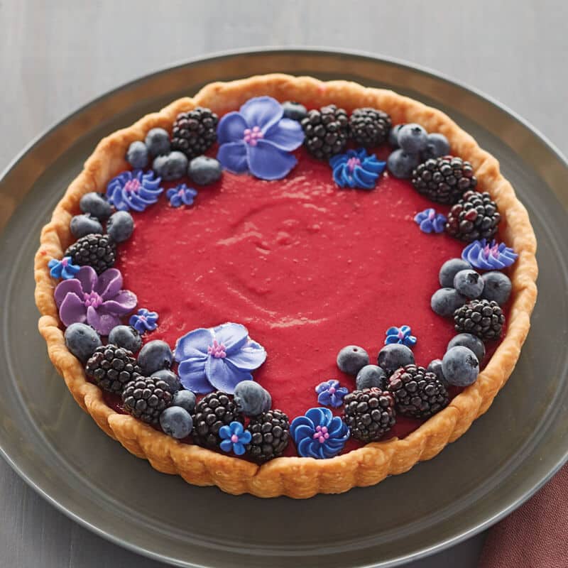 Cranberry curd tart topped with black and blue berries