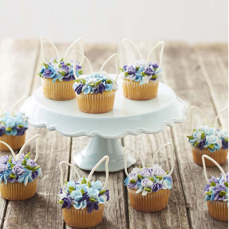 cupcakes decorated with buttercream frosting blooming flowers and bunny ears