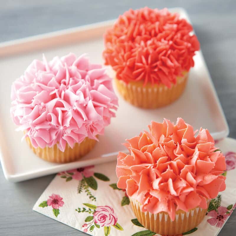 cupcakes pipped with coral colored buttercream frosting