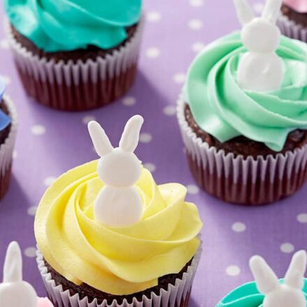 cupcakes topped with a swirl pattern buttercream frosting and topped with an easter bunny decoration