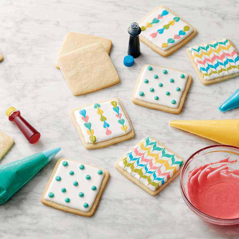 cookies decorated with colored royal icing dots and zig zags