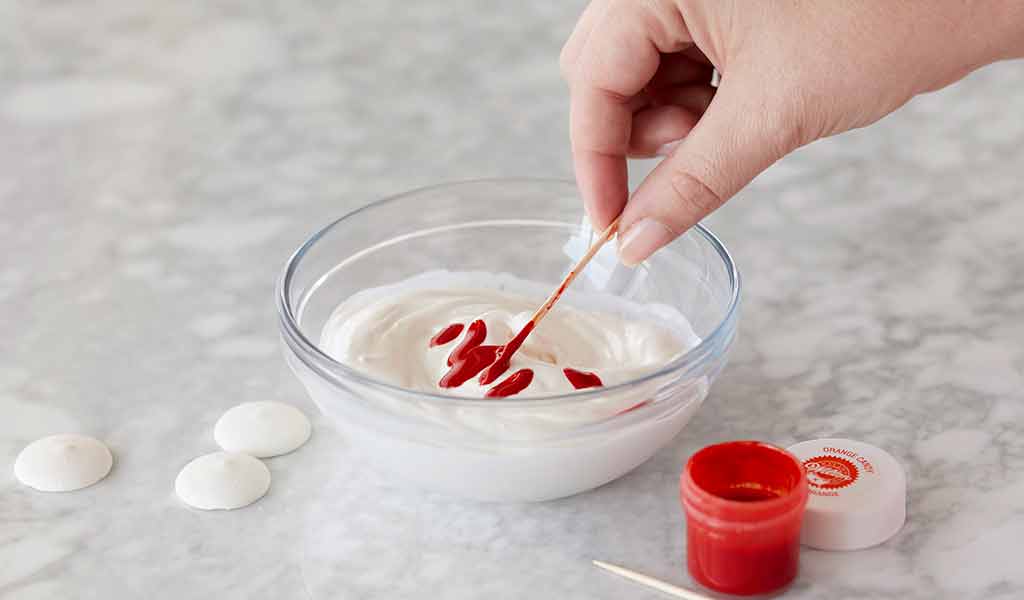 red icing color being used to color white candy melts candy