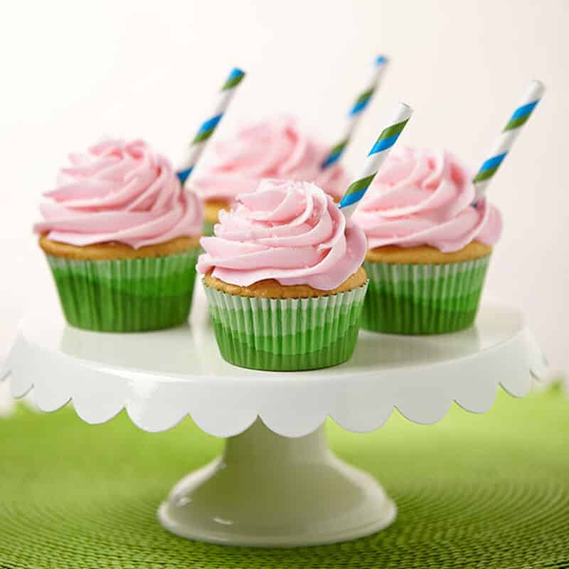 margarita cupcakes decorated with pink buttercream frosting and straws