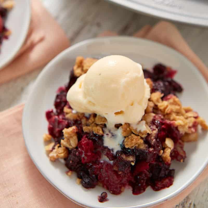 mixed berry crisp with vanilla ice cream on top