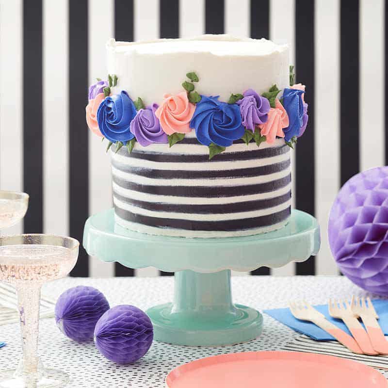 black and white buttercream cake with pink and blue buttercream rosettes